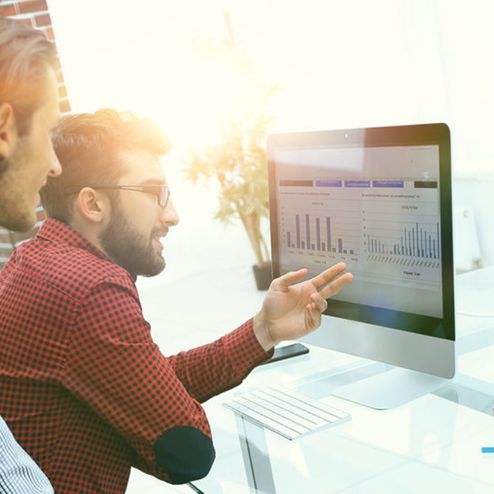 2 men at computer looking at Drive Sales and Fuel Growth graphs